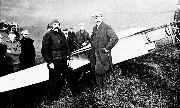 Louis Blériot et des hommes posent près d’un avion en 1909
